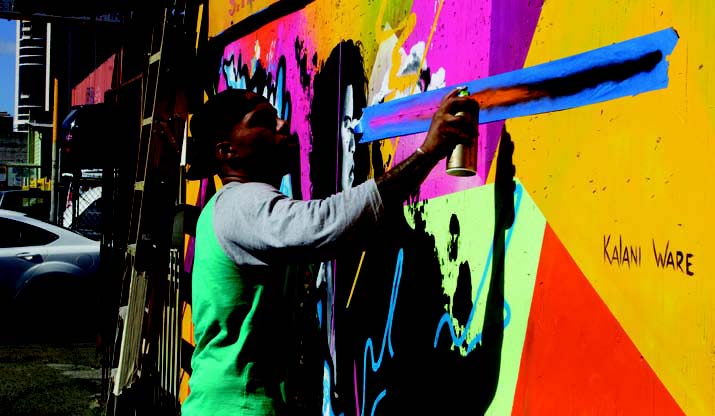 Oakland graffiti artist Kalani Ware working on his abstract mural at Pow! Wow! Hawai‘i – Dutches K. Richards